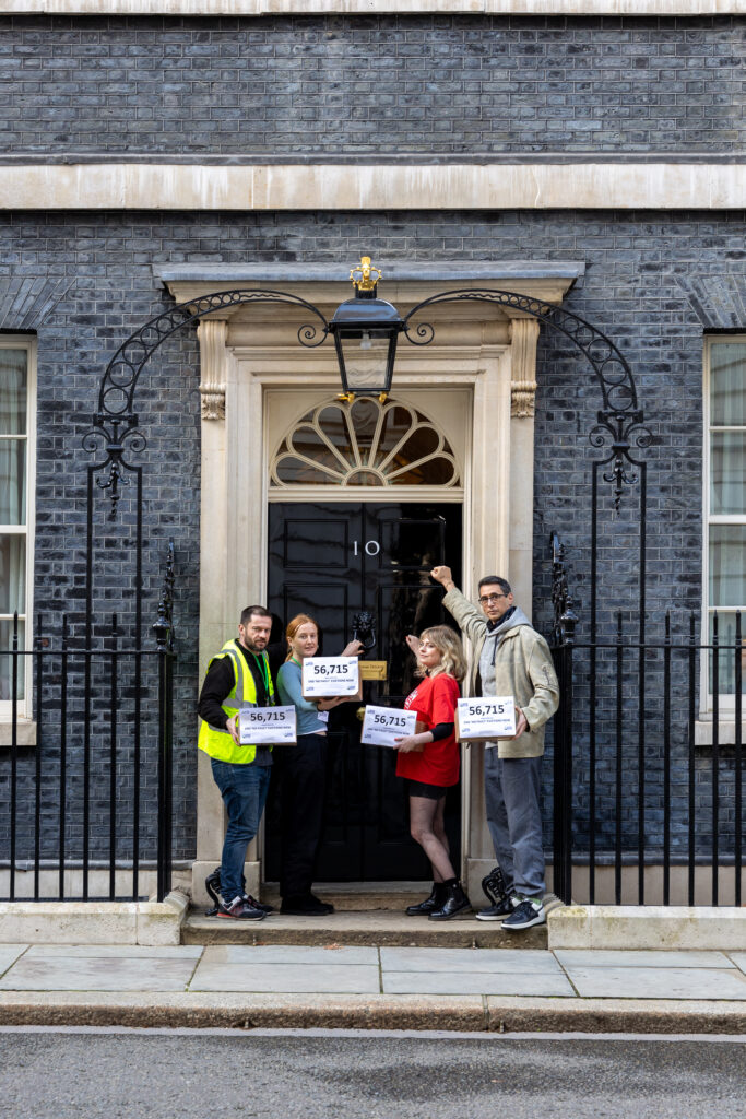 Group of people handing in a petition at the door of number ten, Downing Street.