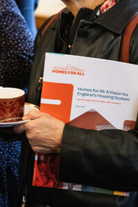 A person holding a copy of the report under their arm