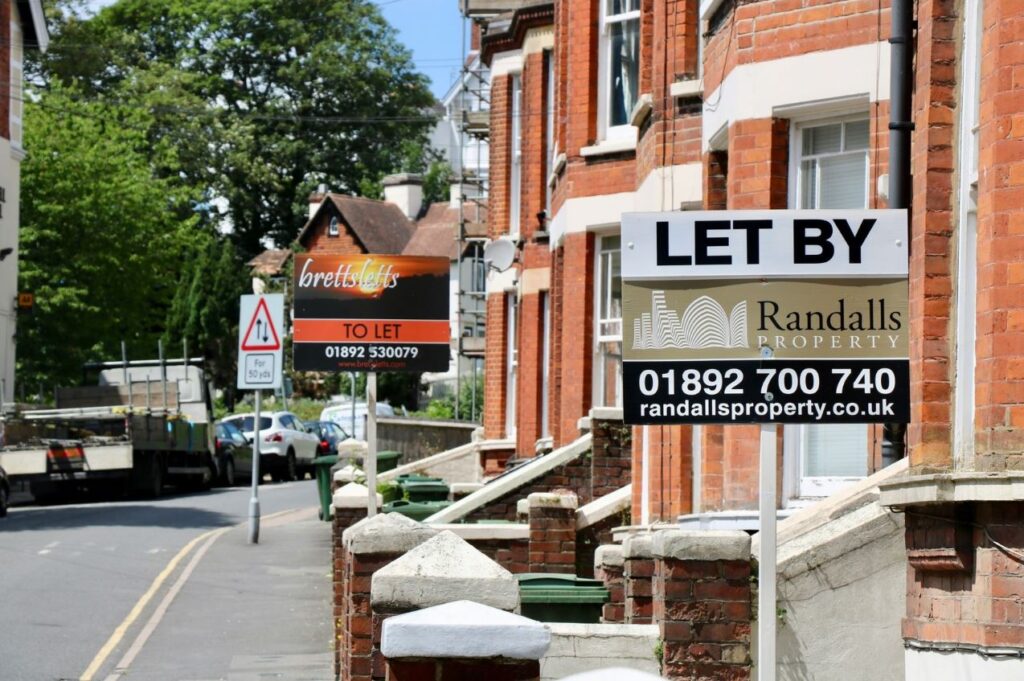 Image of a residential street with two 'to let' signs outside houses