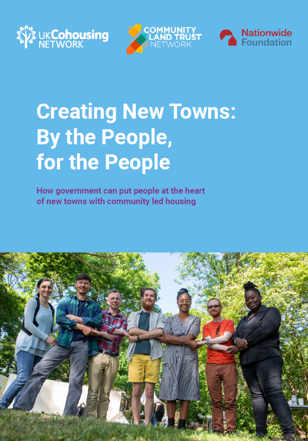 Photo of the front cover of a report. The top half is blue with the title of the report 'Creating New Towns: By the People, FOr the people'. The bottom half shows a row of people holding hands in a sunny field